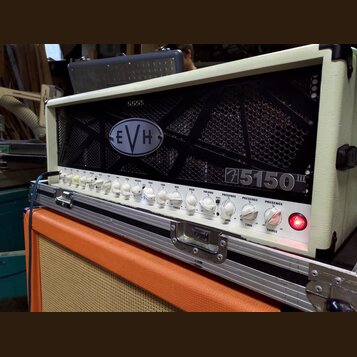 Kytarový zesilovač v bílém krytu s černou mřížkou, na které je umístěno logo EVH. Na pravé straně mřížky je nápis 5150 III. Přední panel obsahuje řad…