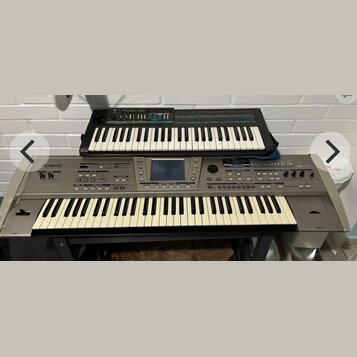 Dvě klávesové nástroje umístěné na sobě. Spodní šedý instrument nese nápisy Roland a DISCOVER 5 REALTIME ORCHESTRATOR. Horní černý instrument má nápi…