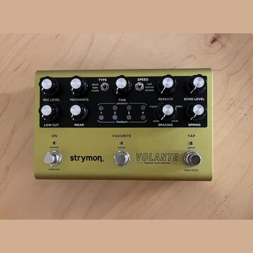 Zlatý efekt pedál s nápisy strymon, VOLANTE a Magnetic Echo Machine. Zařízení má osm černých otočných ovladačů, tři kovové spínače a čtyři kontrolní…