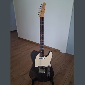 Elektrická kytara typu Telecaster s černým tělem a bílým pickguardem. Na hlavě hředu je viditelné logo "Laney". Nástroj má tmavý hmatník a je umístěn…
