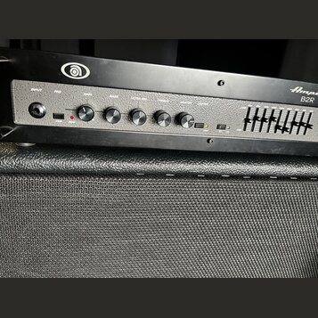 Černý basový zesilovač s nápisy Ampeg a B2R. Přední panel obsahuje vstup INPUT, přepínač PAD, čtyři otočné ovladače s popisky GAIN, BASS, ULTRA MID a…