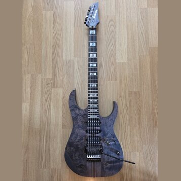Elektrická kytara s tmavě fialovým průsvitným povrchem s viditnou strukturou dřeva. Na hlavě hmatníku je bílý nápis Ibanez. Nástroj má dva humbuckery…