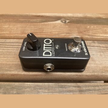 Černý kytarový pedál s nápisy DITTO a LOOPER. Na pravé straně je logo tc electronic a přepínač s nápisem TRUE BYPASS, na levé straně je otočný knoflí…