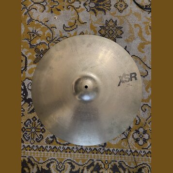 Kruhový činel z kovu v matné stříbrno-zlaté barvě. Na pravé straně je černý nápis „SR“ a pod ním menší text „Size: 14"/34 cm“. Povrch vykazuje drobné…