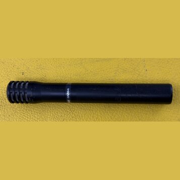 Černý dynamický mikrofon s mřížkou v horní části. Na těle je viditelný bílý nápis „RE SM94“. Povrch vykazuje drobné známky opotřebení v podobě škrába…