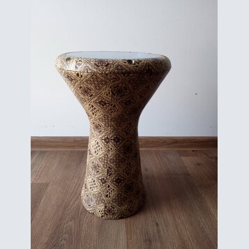 Fotografie zobrazuje buben typu djembe s tělem potaženým vzorníkovou tkaninou v hnědých a béžových odstínech. Horní hrana je zakončena světlým napína…