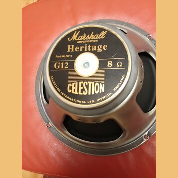 Kruhový reproduktor s kovovým rámem a černou membránou. Na středovém štítku jsou nápisy Marshall AMPLIFICATION Heritage, Part No.S311, G12 8 Ω a CELE…