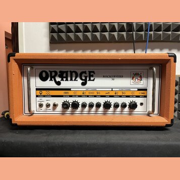 Kytarový zesilovač v oranžovém texturovaném potahu s černými hranami. Na předním panelu je velký nápis ORANGE a označení ROCKERVERB 50 spolu s logem.…