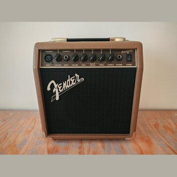 Kytarový kombozesilovač s hnědým texturovaným povrchem a černou přední síťovkou. Na síťovce je bílé logo Fender. Horní ovládací panel obsahuje nápisy…