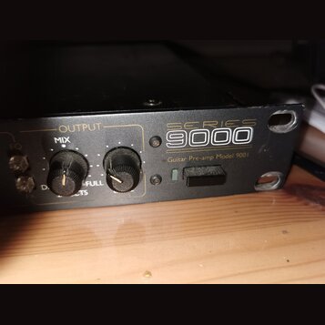 Černý rackový přístroj s nápisy SERIES 9000 a Guitar Pre-amp Model 9001. Na předním panelu jsou dva černé otočné ovratky s popisky OUTPUT, MIX a FULL…