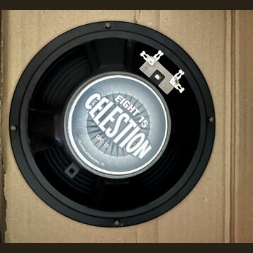 Černý reproduktor s kovovým rámem a připojovacími svorkami. Uprostřed je štítek s nápisy CELESTION, EIGHT 15, GBC-15 a CELESTION INTERNATIONAL LTD. P…
