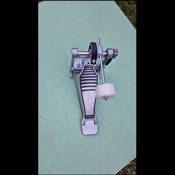 Kovový pedál bicího bubnu stříbrné barvy. Na spodní části stupně je vyražen nápis YAMAHA. Beater má bílý plstěný nástavec. Povrch vykazuje běžné znám…