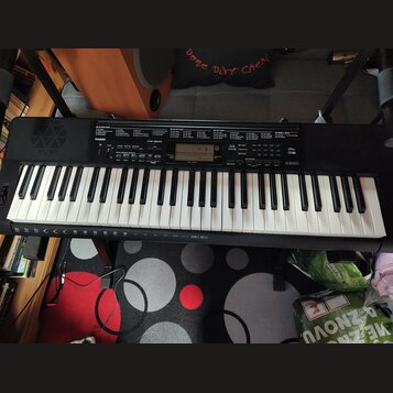 Černý digitální klavír s bílými a černými klávesami. Na levé straně ovládacího panelu je bílé logo CASIO a vedle něj nápis CTK-3500. V dolní části po…