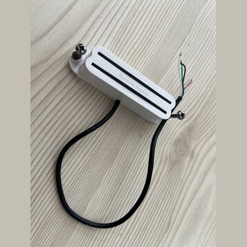 Bílý humbucker s dvěma černými vodicemi. Na povrchu je nápis Seymour Duncan. Z nástroje vedou čtyři barevné vodiče a jeden černý kabel.