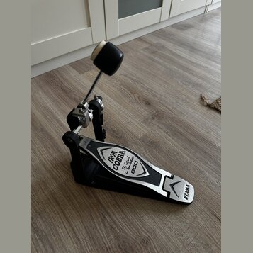 Fotografie zobrazuje černý basový pedál s kovovými prvky. Na šlapce je nápis IRON COBRA, The legend iron footboarder a modelové označení 600. Na patě…