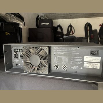 Šedý rackový výkonový zesilovač s kovovým šasi a vestavěným ventilátorem. Na zadním panelu jsou vidět dva konektory SpeakON, napájecí vstup a přepína…