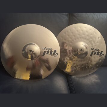 Dvě kovové činely v barvě zlaté. Na levém je nápis pAiste pst8 14" ROCK HATS BOTTOM a na pravém, který má povrch s důlky, nápis pAiste pst8 14" ROCK…
