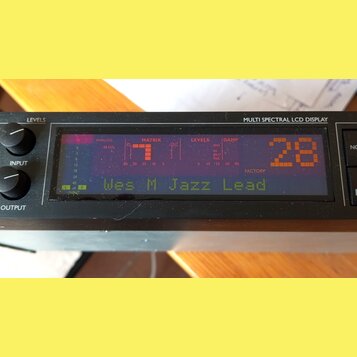 Detailní pohled na černý elektronický přístroj s nápisem MULTI SPECTRAL LCD DISPLAY. Displej zobrazuje červené a zelené texty a grafy, včetně nápisů…