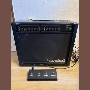 Černý kytarový kombo zesilovač s nápisem Randall na přední mřížce. Na horním ovládacím panelu je uveden model RG50TC a nápis 50 WATT TUBE COMBO. Před…