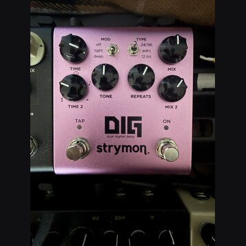 Fialový efekt pedál s nápisy DIG, dual digital delay a strymon. Na horní straně jsou čtyři černé otočné knoflíky s popisky TIME / TIME 2, TONE, REPEA…