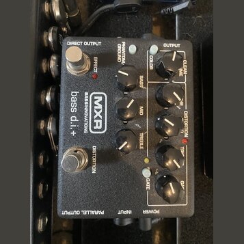 Černý efekt pedál s nápisy MXR, BASSINNOVATIONS a bass d.i.+. Zařízení má dva stomečové spínače označené EFFECT a DISTORTION, pět otočných potenciome…