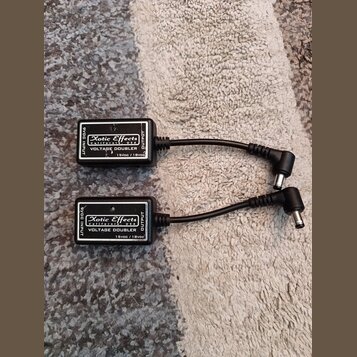 Dvě černé krabičky s napájecími kabely. Na obou je bílý nápis Xotic Effects, California, USA, VOLTAGE DOUBLER a 15Vdc / 18Vdc. Na bocích jsou označen…