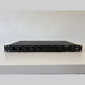 Černý rackový procesor s nápisem Vitalizer a logem spl. Přední panel obsahuje osm otočných ovladačů s popisky DRIVE, BASS SOUND, BASS COMP, MID-HI TU…