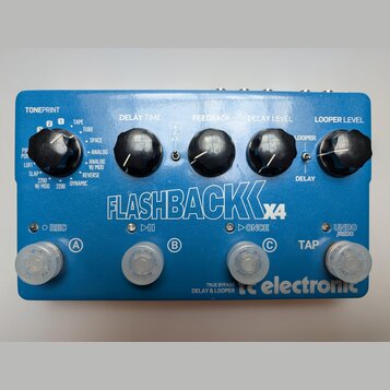 Modrý efekt pedál s nápisem FLASHBACK X4 a logem tc electronic. Na horní straně se nachází pět černých otočných ovladačů s popisky TONEPRINT, DELAY T…