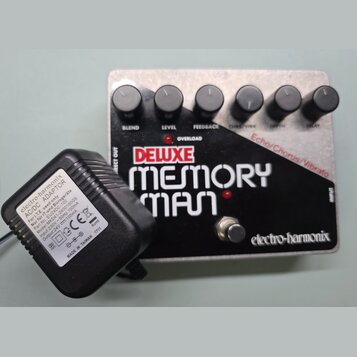 Kytarový efekt v kovovém šasi s černým povrchem a stříbrnými okraji. Na přední straně je bílý nápis DELUXE MEMORY MAN a v pravém dolním rohu logo ele…