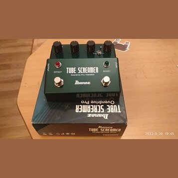 Zelený efekt pedál s kovovým šasi a čtyřmi černými ovládacími knoflíky. Na přední straně je bílý nápis TUBE SCREAMER, Overdrive Pro TS808DX a logo Ib…