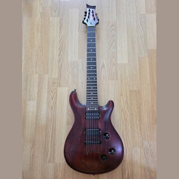 Elektrická kytara s tmavě hnědým dřevěným povrchem a černým hmatníkem. Na hlavě je viditelné logo "Schecter". Nástroj má jeden humbucker v pozici kob…