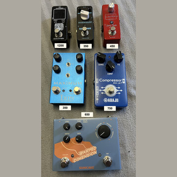Fotografie zobrazuje pět kytarových efektů. V horní řadě jsou tři pedály: černý s nápisy „EHX-2020“, „PITCH“, „FLATT“ a logem „electro-harmonix“, čer…