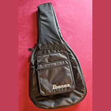 Černý poloměký pouzdro (gig bag) na kytaru. Na přední kapse je bílý nápis Ibanez. Povrch materiálu vykazuje mírné pomačkání a známky používání.
