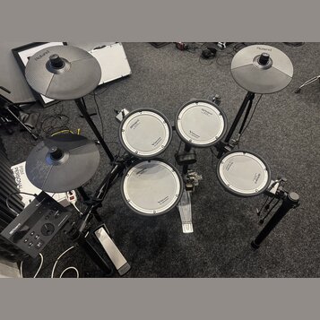 Elektronická bicí souprava značky Roland v černé barvě. Na čelech padů a na činelech je vidět logo Roland, u padů jsou dále nápisy V-Drums a V-Drum.…
