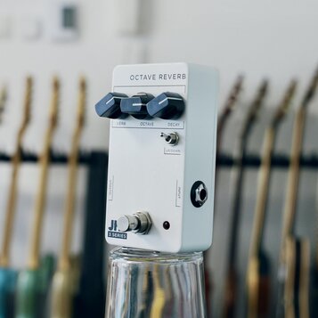 Bílý efekt pedál s nápisem OCTAVE REVERB. Na horní straně jsou tři černé ovládací knoflíky s popisy VERB, OCTAVE a DECAY, dále malý přepínač s nápise…