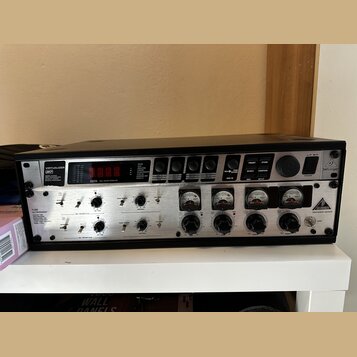 Černý rackový procesor s kovovým předním panelem. V horní části je nápis VIRTUALIZER VD a logo Behringer, v dolní části nápisy TUBE ULTRAGAIN a VINTA…