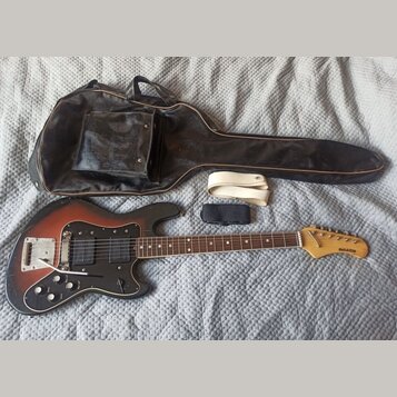 Elektrická kytara s červeně-žlutým sunburst povrchem, černým pickguardem a hnědým hmatníkem. Na hlavě je nápis GALAXIE. Kytara má jeden humbucker, je…
