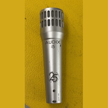 Stříbrný dynamický mikrofon s mřížkou v horní části. Na těle je černý nápis AUDIX i5 a níže logo s číslem 25 v kruhu. U spodního konce je svisle naps…