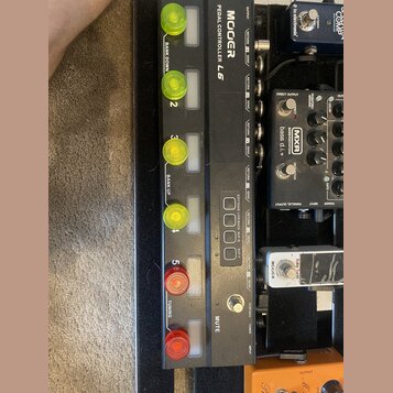 Černý MIDI kontrolér s nápisem MOOER PEDAL CONTROLLER L6. Zařízení má čtyři žlutá a dvě červená zapadací tlačítka, z nichž některá jsou popsána nápis…