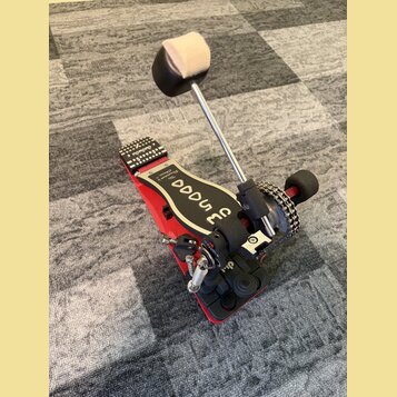Červený basový pedál s černými doplňky a kovovými součástmi. Na černé části je bílý nápis „Snaare“ a menší text „740 Drum Pedal“. Pedál vykazuje mírn…