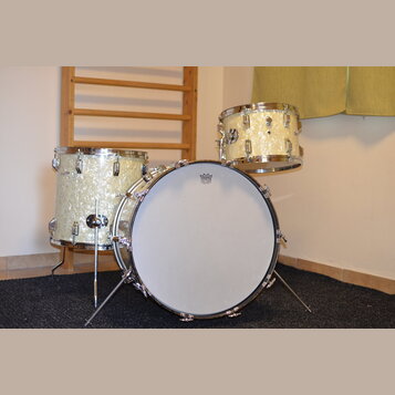 Sada bubnů v krémové perleťové barvě s chromovaným kováním. Na přední bláně basového bubnu je logo „PREMAQ“ a pod ním nápis „Professional Drum BASS D…