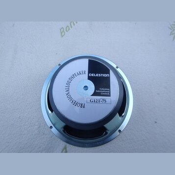 Kruhlový reproduktor s kovovým rámem. Na bílém středovém krytu je černý nápis PROFESSIONALLOUDSPEAKER a logo CELESTION. Dále je zde text Celestion In…