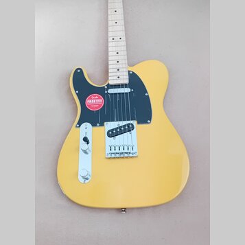 Žlutá elektrická kytara typu Telecaster s černým plechtrátem a světlým hnízdovcem. Na plechtrátu je nalepená červeno-bílá kulatá nálepka s nápisem Fe…