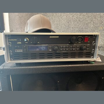 Stříbrný rackový case obsahuje dvě zařízení značky SAMSON. Horní jednotka má nápis PowerBrite PB10, ovládací prvky pro SHIMMER a LAMP a červený vypín…