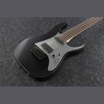 Černá elektrická kytara s matným povrchem a šedým pickguardem. Nástroj má dva humbuckery, tremolo most a hnedý hmatník. Na kytáře nejsou viditelné žá…