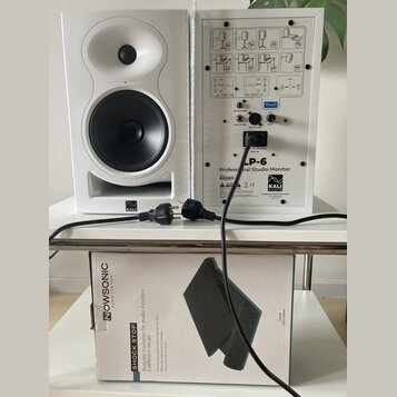 Dvě bílé studiové monitory značky KALI, jeden zepředu a druhý zadní stranou. Zadní panel obsahuje nápis LP-6 Professional Studio Monitor, logo KALI a…