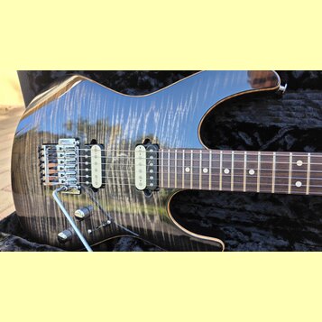 Elektrická kytara s tmavým lakovaným povrchem a viditnou strukturou dřeva. Nástroj má dva humbuckery, chromovaný most s páčkou a dvě ovládací knoflík…