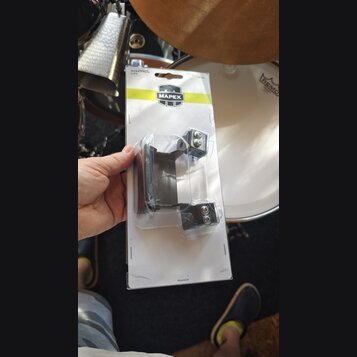 Fotografie znázorňuje příslušenství k bubnu v originálním plastovém obalu na kartonovém podkladu. Na žlutém pruhu je logo MAPEX a nápisy BASS DRUM LI…