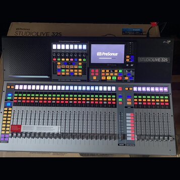 Digitální mixovací pult v šedé barvě s černým horním panelem. Na přístroji jsou viditelné nápisy PreSonus a STUDIOLIVE 32S, v horní části je text 32…
