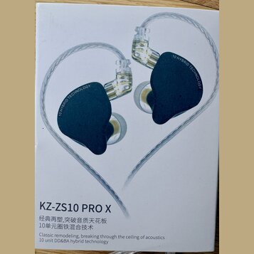 Fotografie krabice s in-ear sluchatky v tmavě modré barvě s průhlednými prvky a stříbrným opleteným kabelem. Na sluchátkách je nápis 10 HYBRID TECHNO…